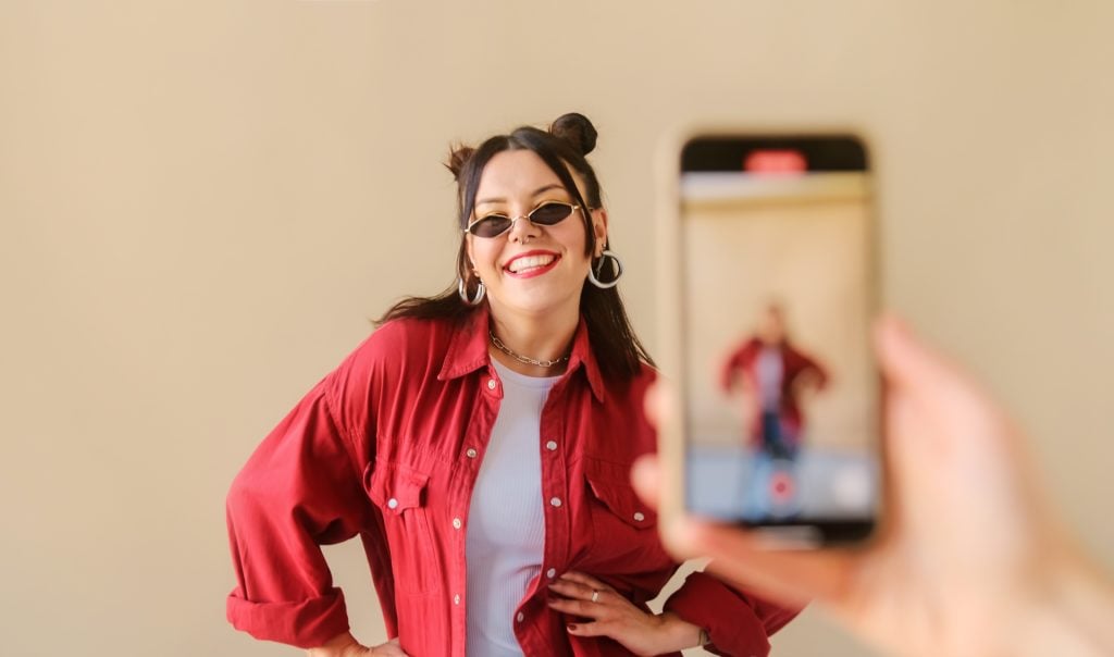 stylish trendy woman recording dance video for tiktok